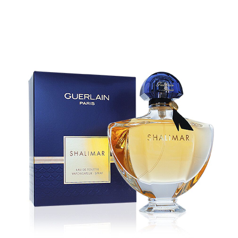 Flacon et emballage. Flacon avec bouchon bleu, étiquette dorée et ruban noir. Boîte bleue avec détails dorés.