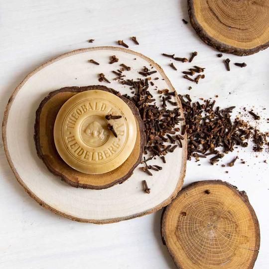 Ronde zeep op houten schijf, kruidnagels en andere houten schijven. Zeep met opdruk: Theobald Klar Heidelberg.