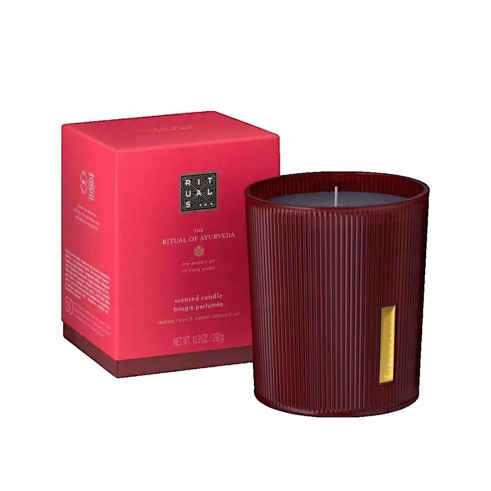 Bougie parfumée rouge dans un récipient en verre cannelé avec une étiquette dorée. Boîte rouge avec logo et texte.