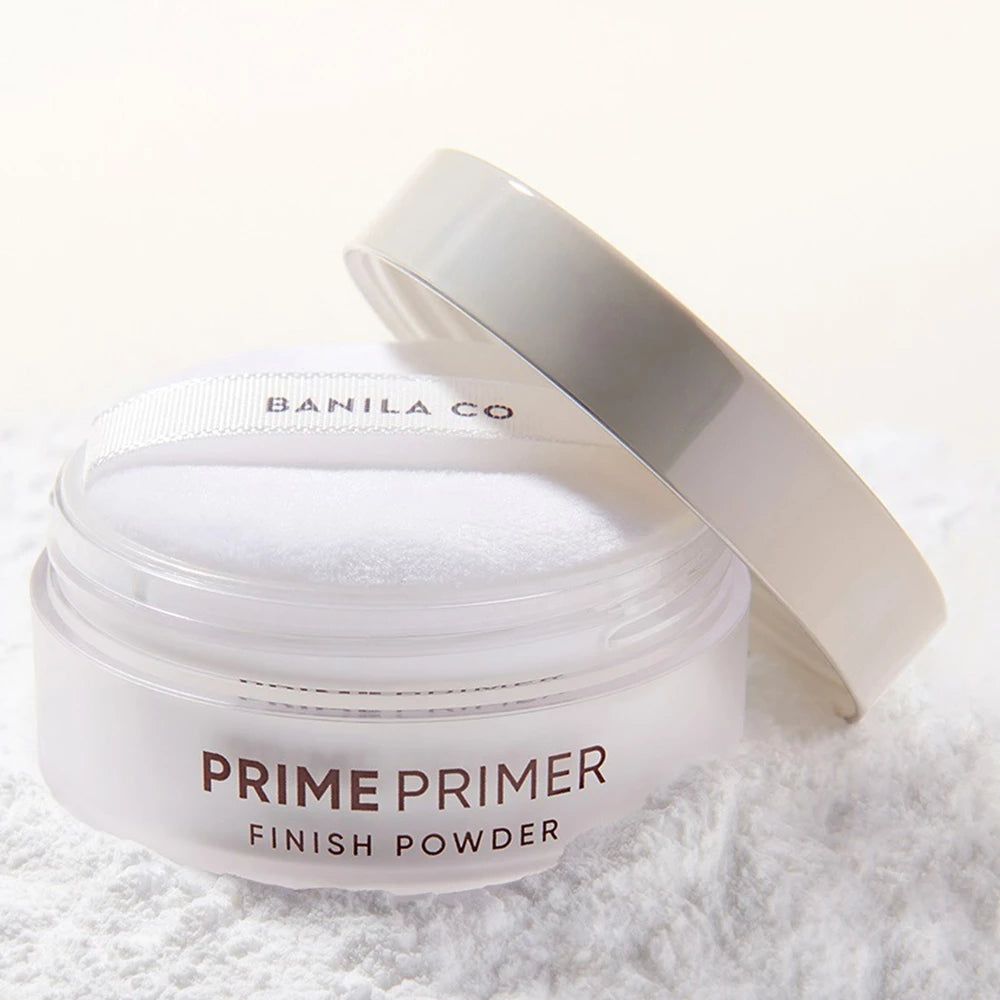 Pot blanc avec couvercle et houppette. Inscription: PRIME PRIMER FINISH POWDER. Poudre sur fond blanc.