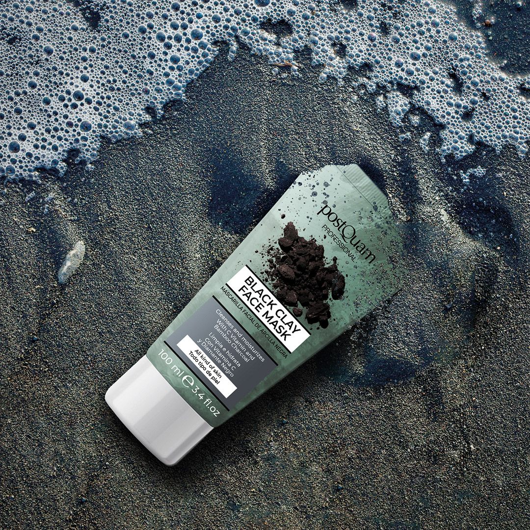 Tube gezichtsmasker op strand. Tekst: Black Clay Face Mask, reinigt en hydrateert met vitamine C en bamboe houtskool. 100 ml.