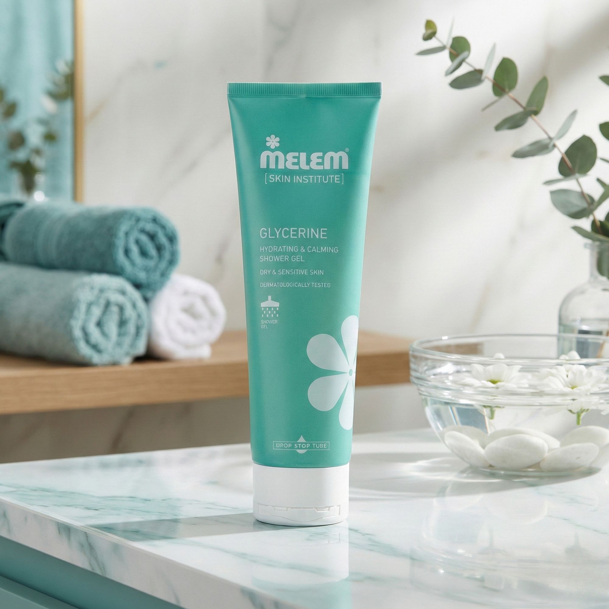 Tube turquoise avec bouchon blanc. Inscription : Melem, Glycerine, Hydrating & Calming Shower Gel. Posé sur une surface en marbre.