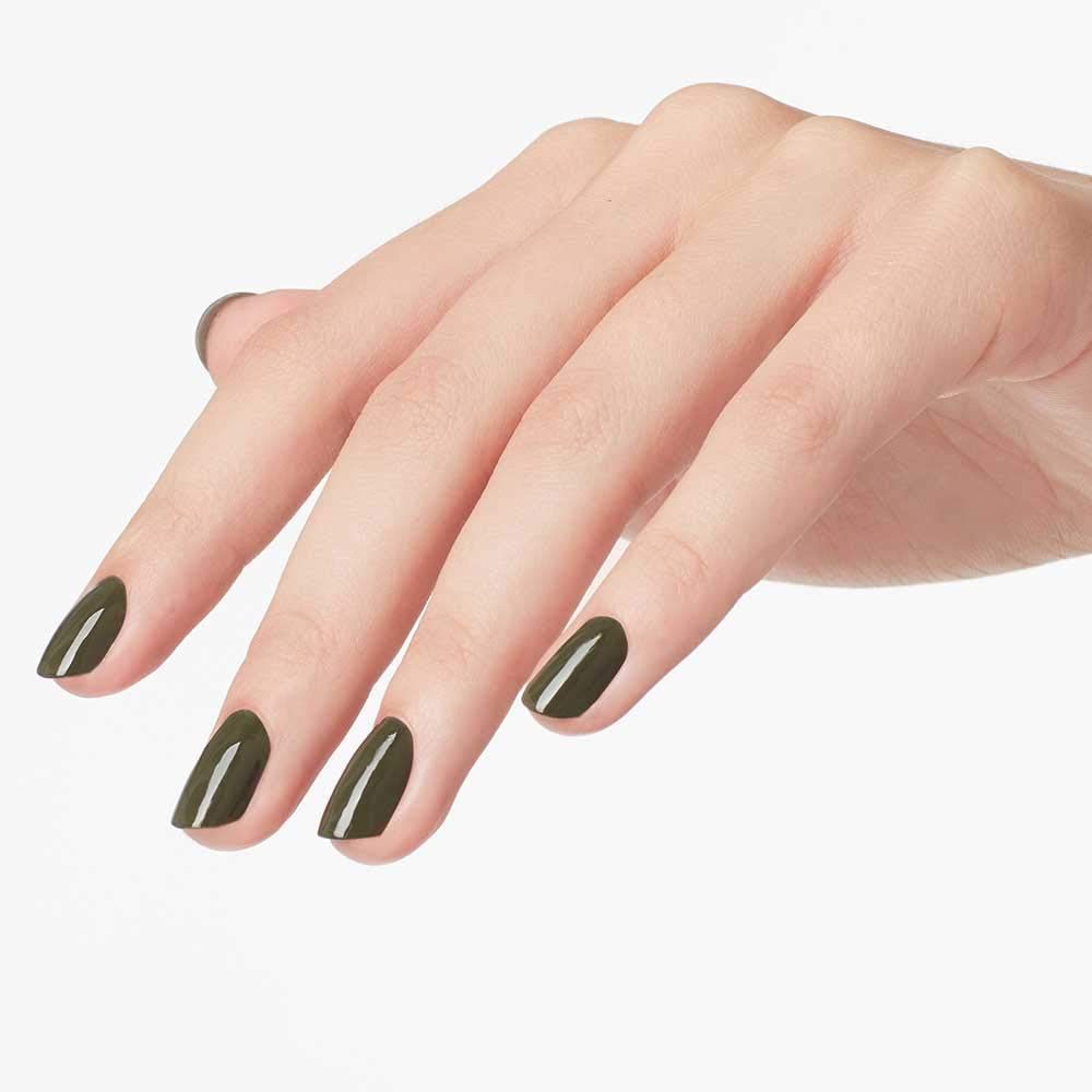 Main avec ongles vernis. Couleur vert olive. Sur fond clair.