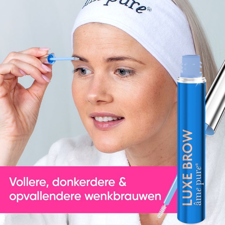 Een vrouw met een hoofdband brengt LUXE BROW wenkbrauwserum aan. Het blauwe flesje met zilveren applicator is goed zichtbaar.