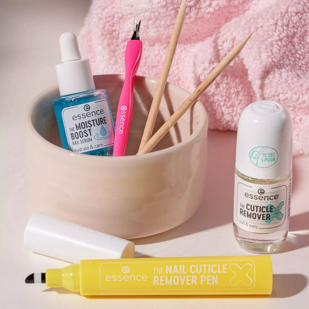 Kit de soins des ongles Essence. Contient sérum, dissolvant, stylos et coupe-cuticules. Serviette rose, fond clair.