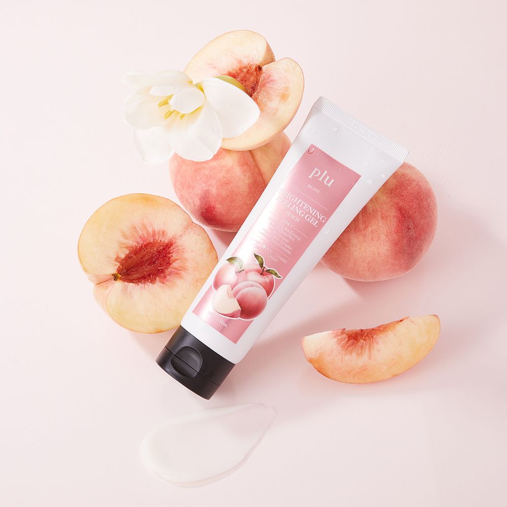 Emballage du produit, pêches et fleur. Texte : PLU Brightening Peeling Gel.