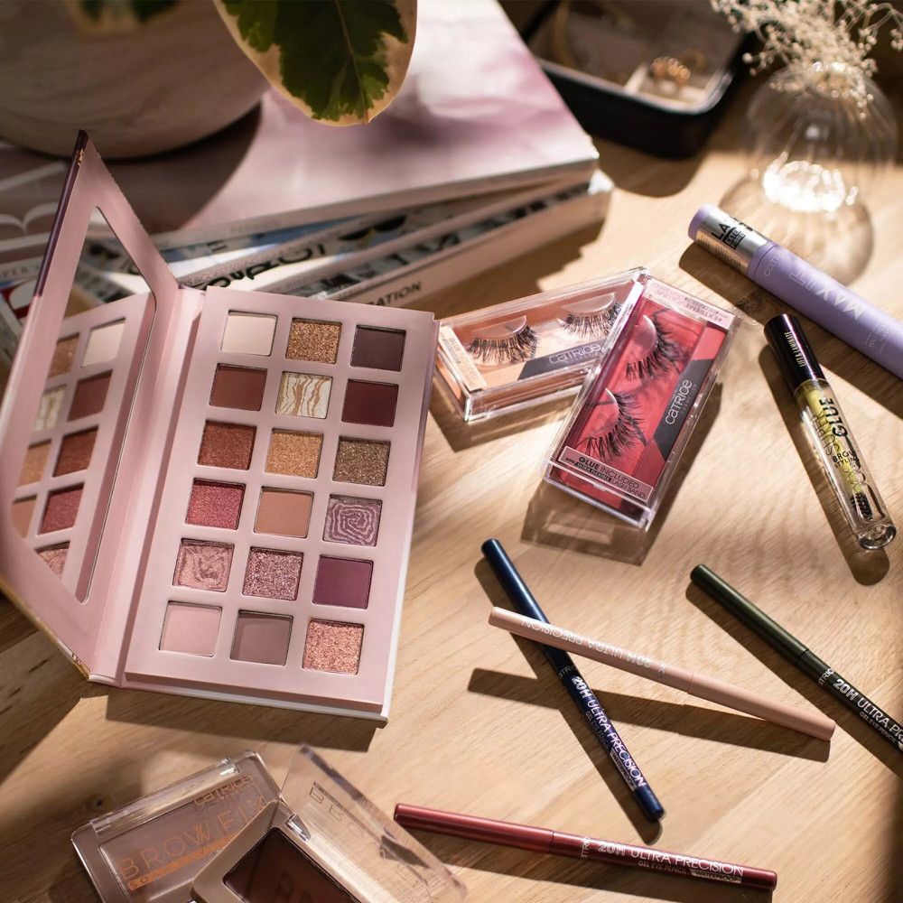 Diverse cosmetische producten op houten oppervlak. Oogschaduwpalet, wimpers, eyeliner, mascara en lijm.