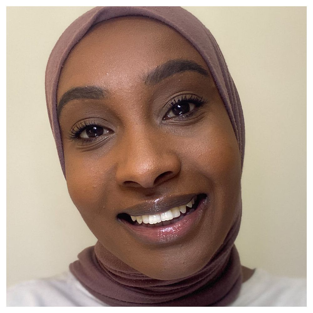 Portrait d'une femme avec du correcteur. Elle porte un hijab.