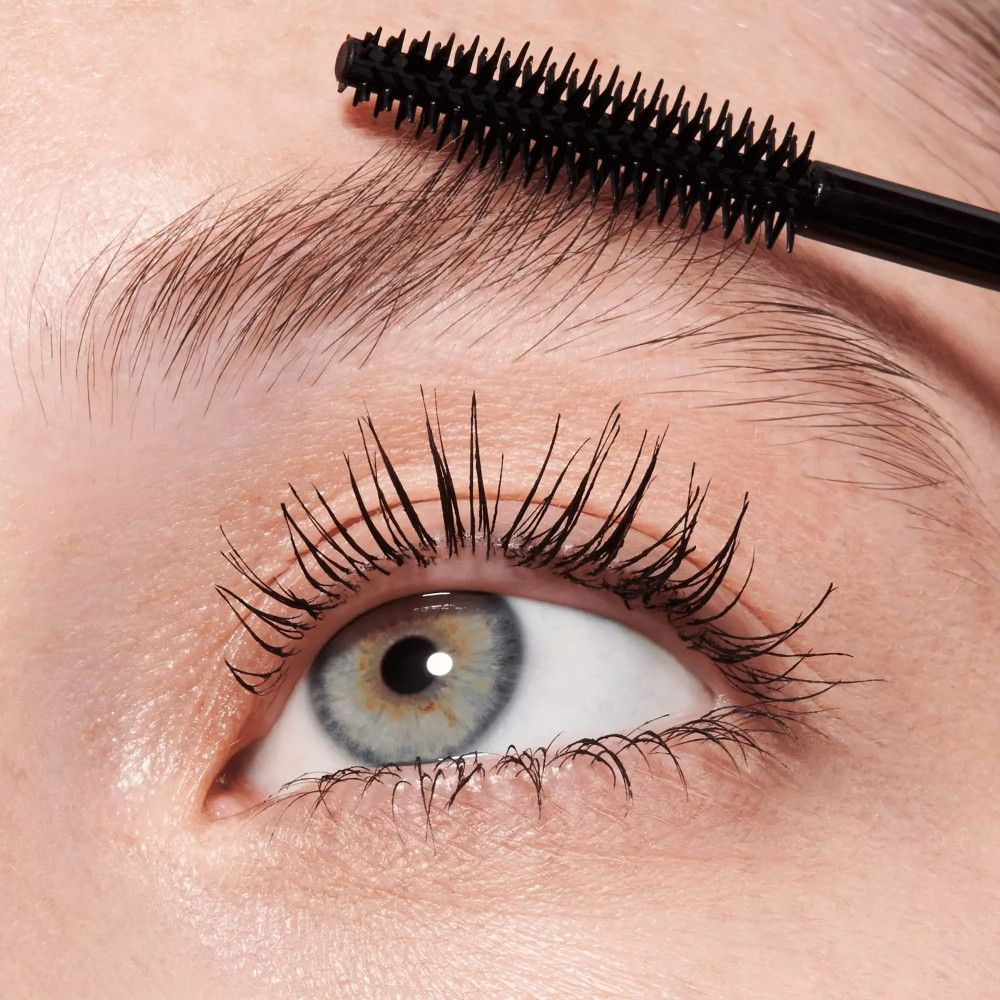 Œil avec cils maquillés. Une brosse à mascara est utilisée pour séparer et définir les cils.