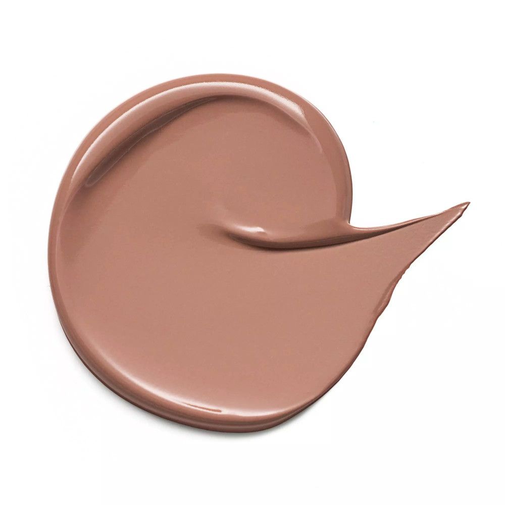Tache de correcteur marron sur fond blanc. Forme ronde avec une extension.