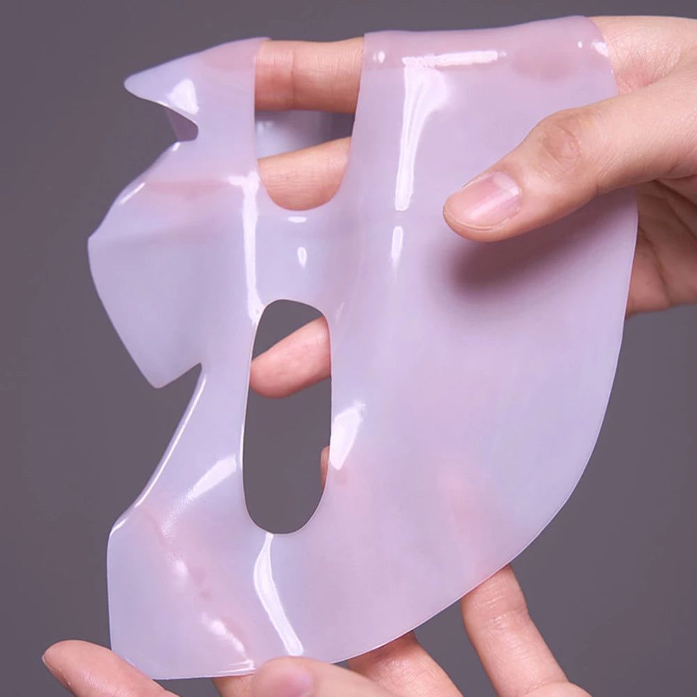 Masque facial translucide, tenu par des mains. Ouvertures pour les yeux, le nez et la bouche.