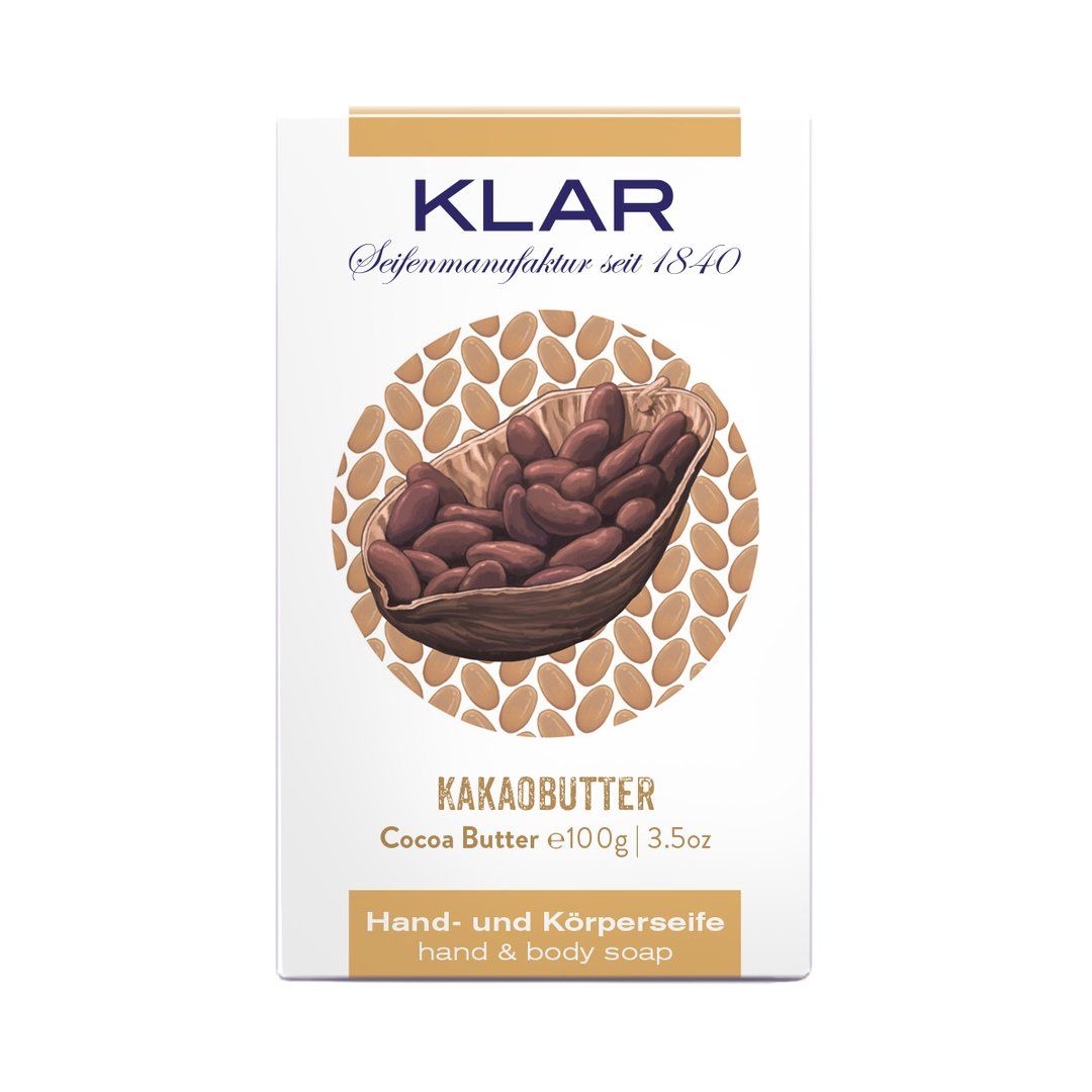 Verpakking van cacaoboterzeep. Opschrift: KLAR, cacaoboter, hand- en lichaamszeep. Afbeelding van cacaobonen.