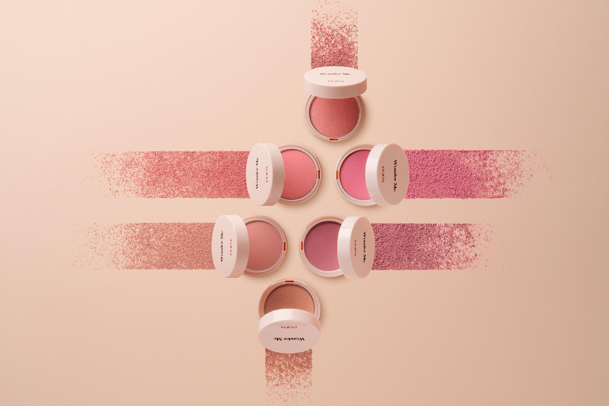 Meerdere blush-containers, gerangschikt in een patroon. Roze poeder op roze strepen.