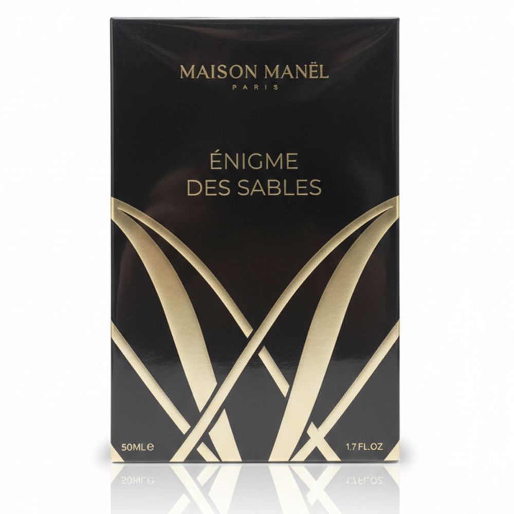 Boîte noire rectangulaire. Inscription dorée: Maison Manel Paris, Enigme des Sables. En bas: 50ml, 1.7 FL.OZ.