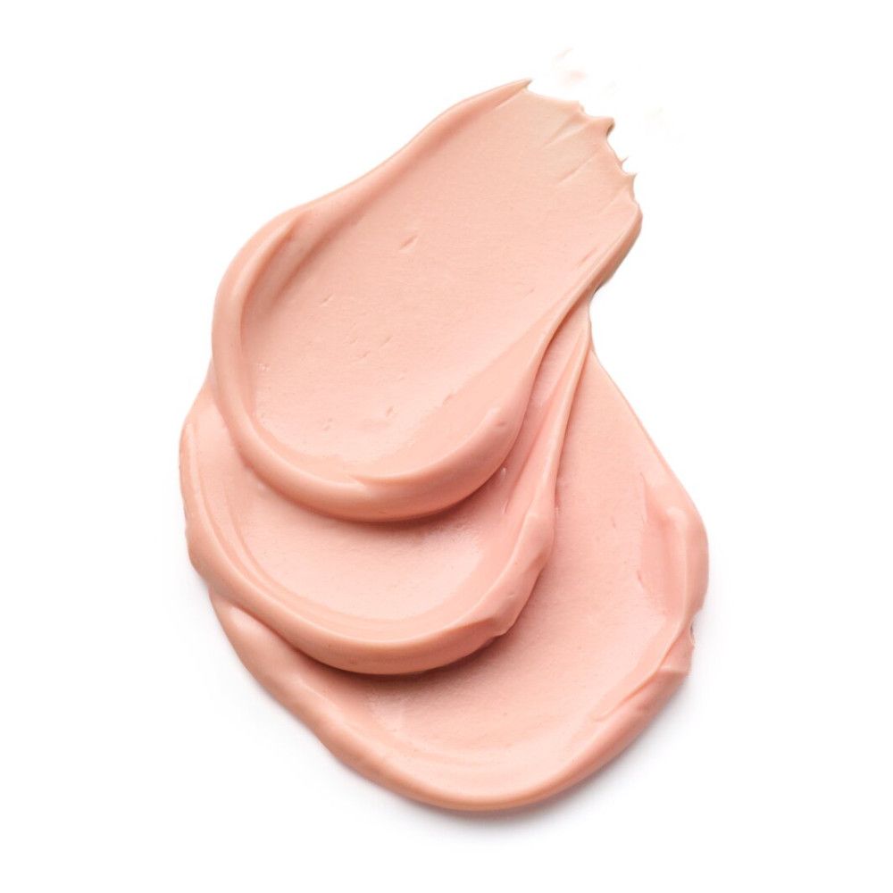 Trois traits de produit crème sur fond blanc. Texture visible.