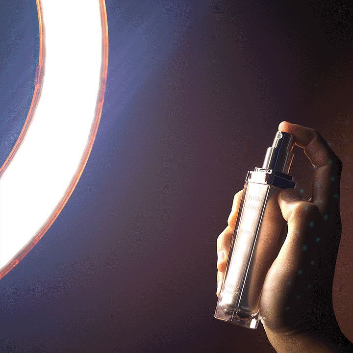 Main tenant le spray âme pure Hydro Elixir devant un anneau lumineux.
