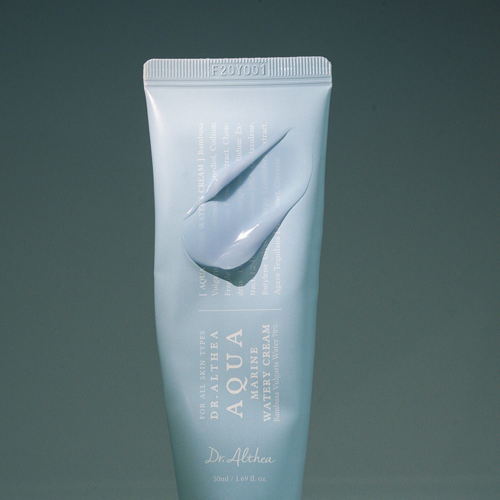 Gros plan d'un tube bleu clair avec informations produit et une touche de crème bleue.