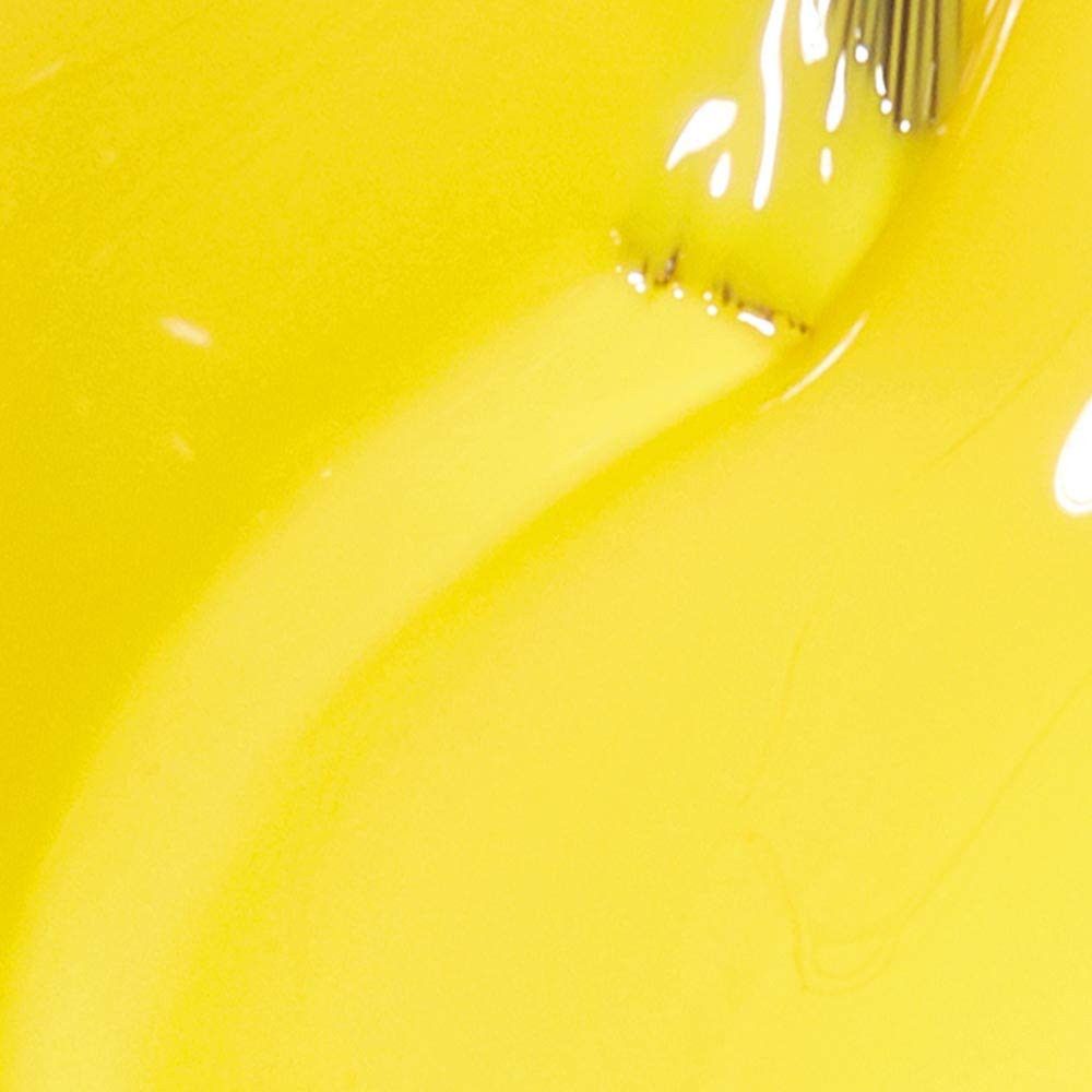 Gele nagellak. Kwast gedeeltelijk zichtbaar. Close-up.