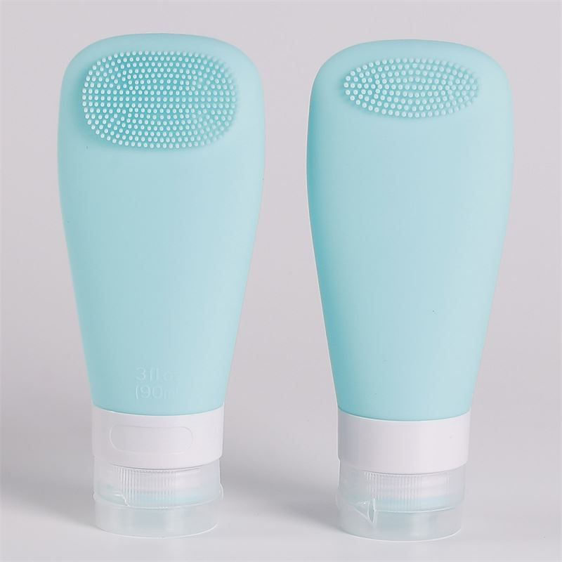Twee turquoise siliconen flesjes met ingebouwde borstel en witte dop.