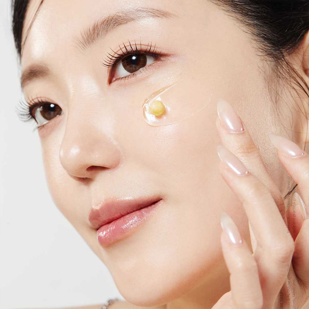 Gros plan d'une femme appliquant la crème en capsules Medicube Deep Vita C.