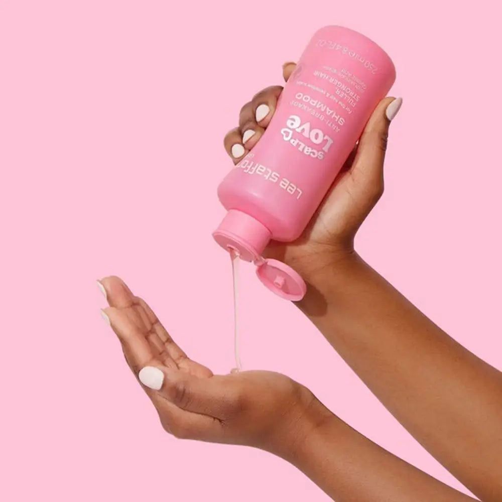 Flacon de shampooing rose versant du liquide dans une main. Inscription : Scalp Love Anti-Breakage Shampoo.