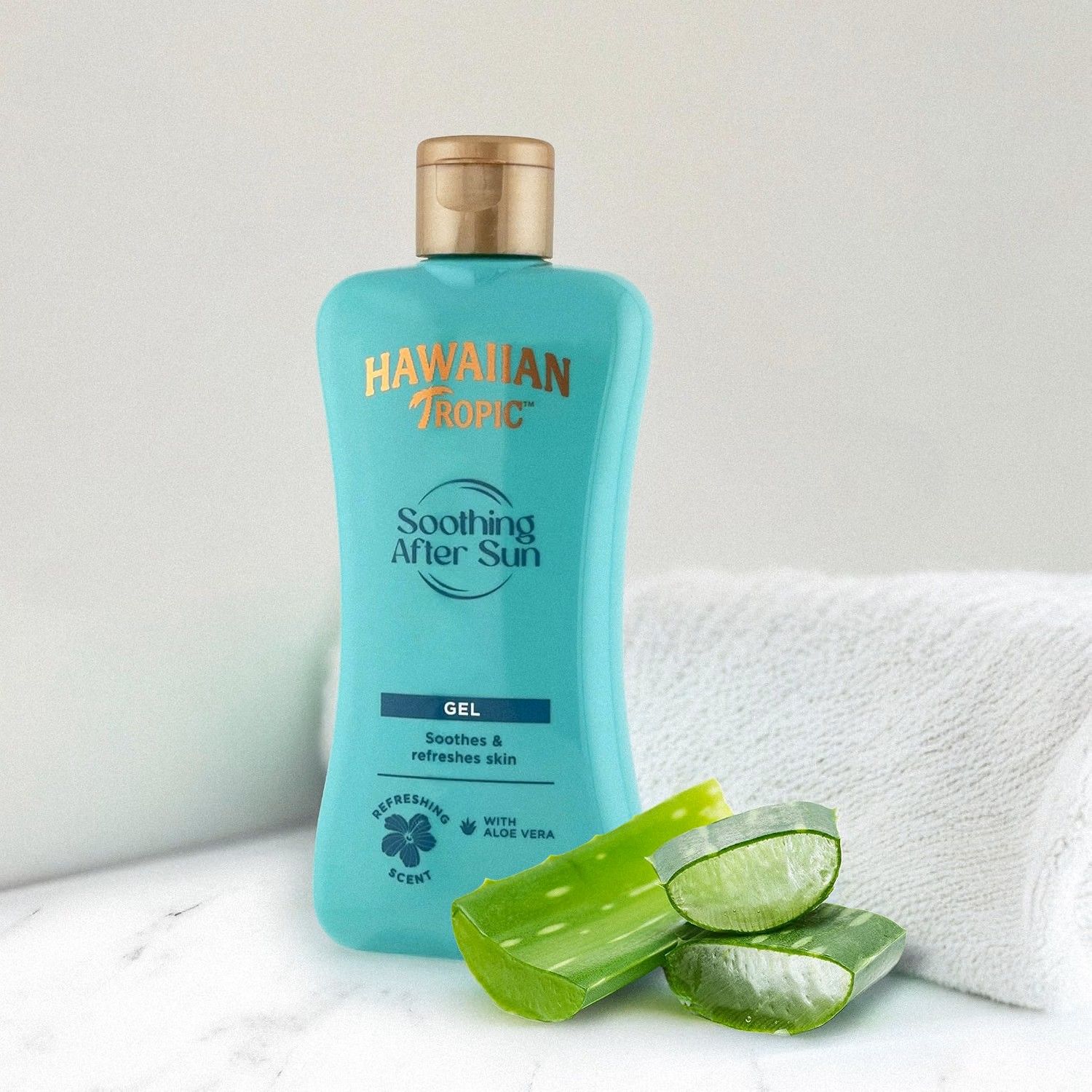 Turquoise fles Hawaiian Tropic Soothing After Sun Gel met aloë vera en een handdoek.