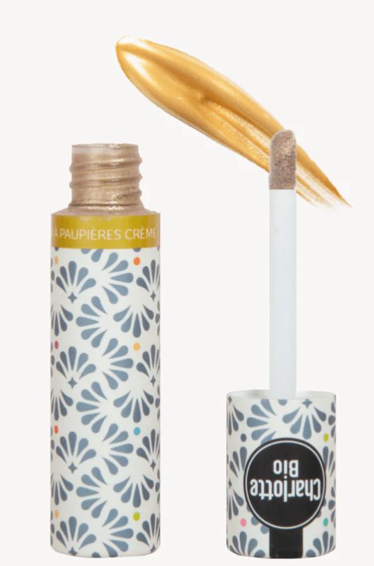Goudkleurige vloeibare oogschaduw in flesje met applicator. Flesje met bloemmotief en tekst Charlotte Bio.