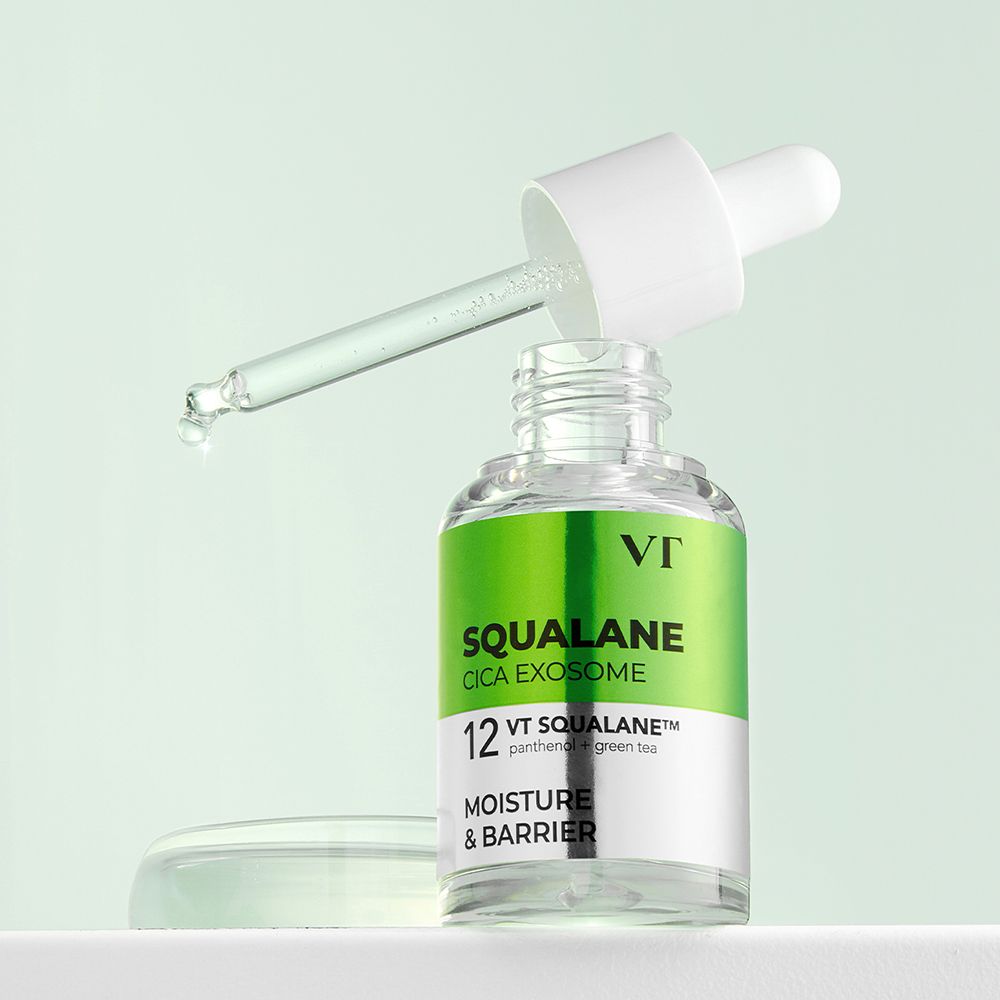 Glazen fles met pipet. Opschrift: Squalane Cica Exosome. Groene en zilveren etiketten. Druppels vallen uit de pipet.