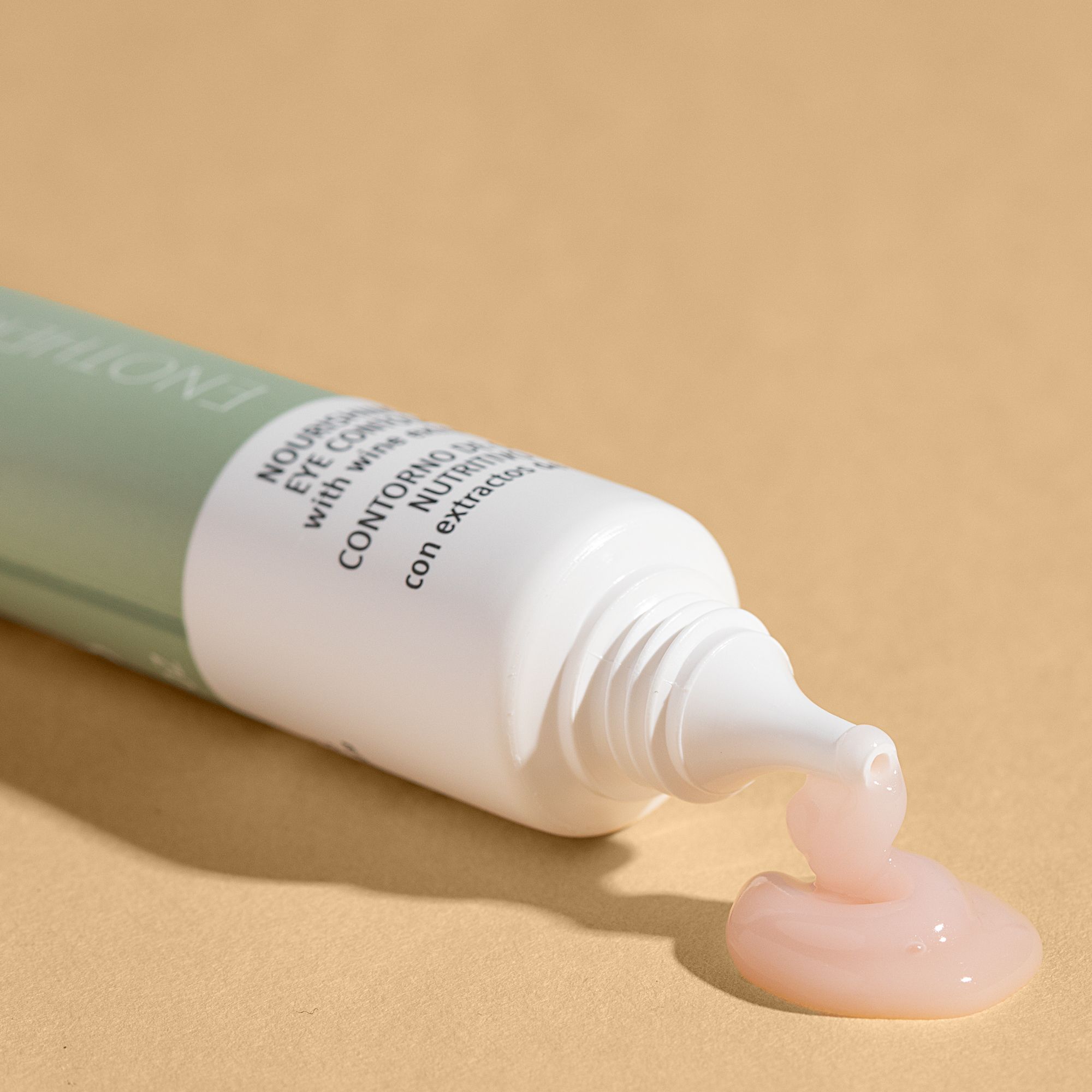 Tube ouvert, crème sortant. Texte: Crème contour des yeux nourrissante. Fond: Beige.