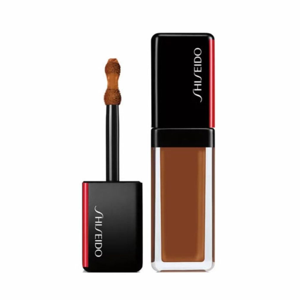 Correcteur Shiseido Synchro Skin. Liquide brun foncé en flacon rectangulaire. Bouchon noir avec accent rouge. Applicateur visible.