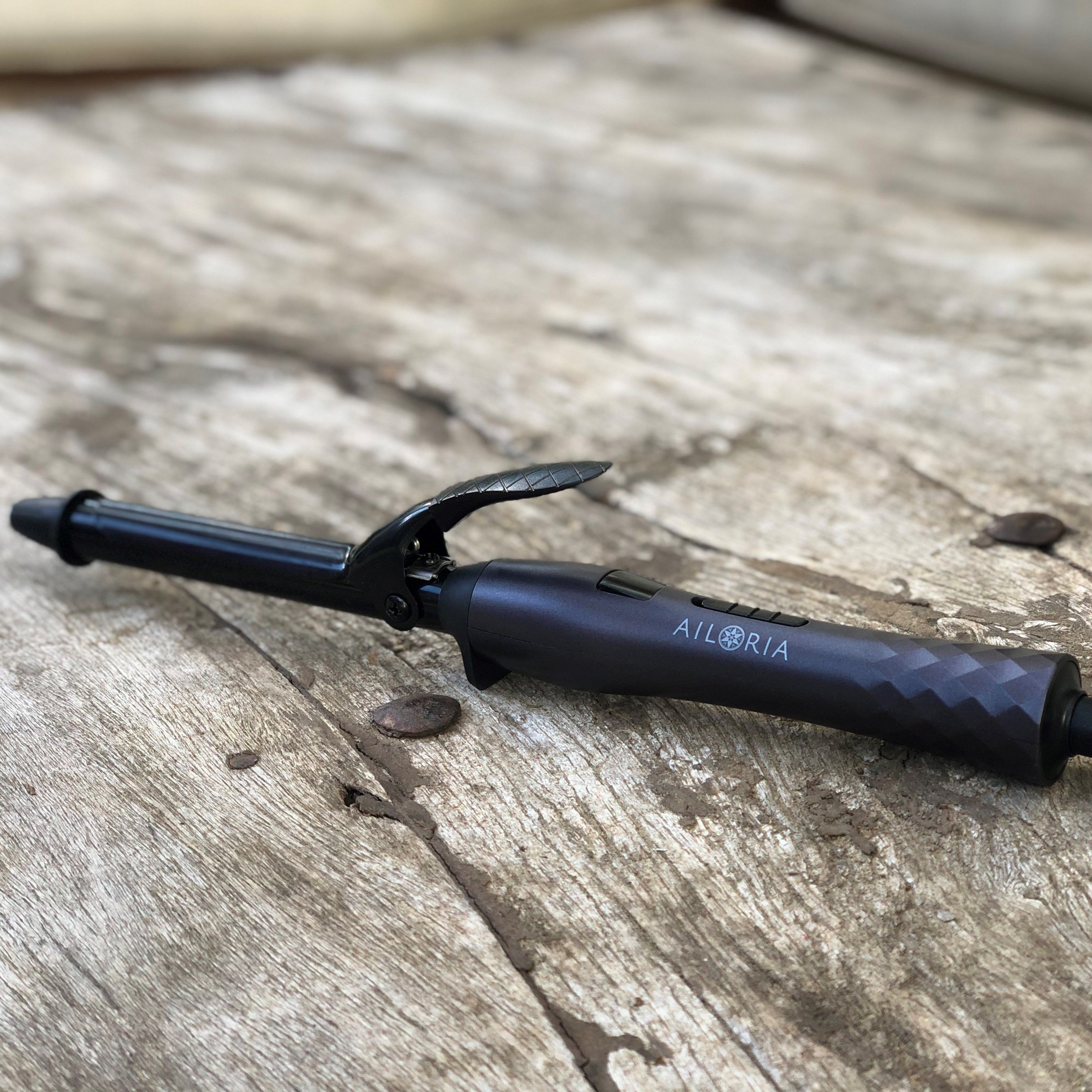 Donkergrijze krultang op houten oppervlak. AILORIA logo zichtbaar. 19mm. Zwart snoer.