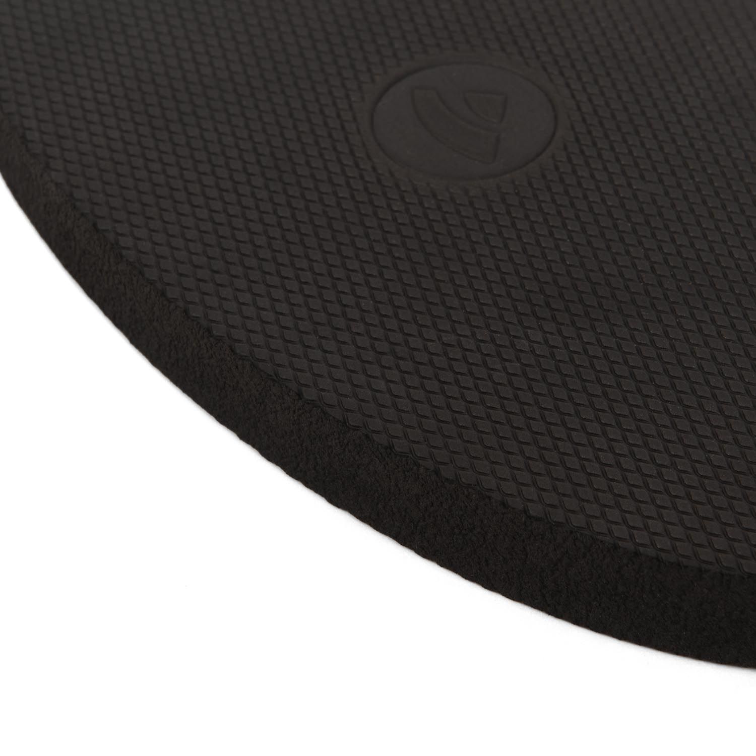 Close-up van de rand van een zwart yoga-pad van EVA-schuim met ruitpatroon.