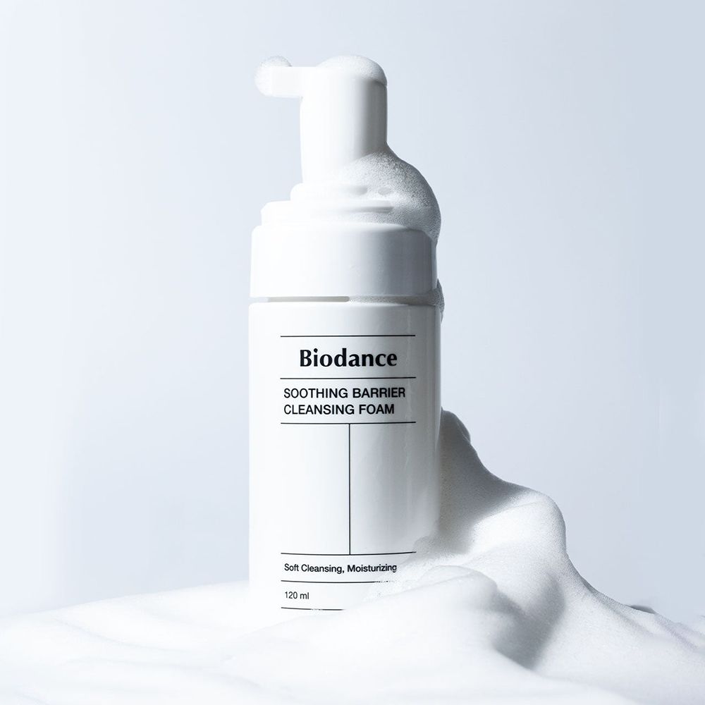 Flacon blanc avec pompe, entouré de mousse. Inscription : Biodance, Soothing Barrier Cleansing Foam.