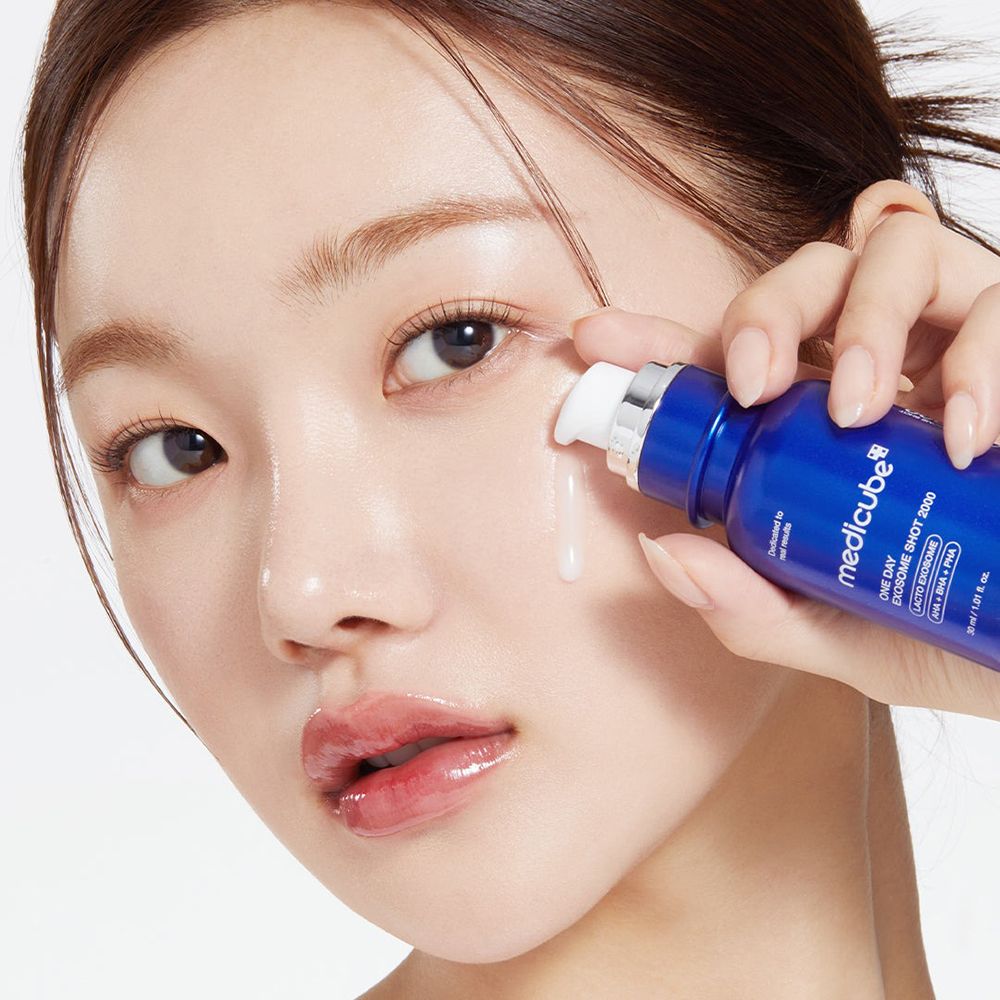 Vrouw brengt product aan. Blauwe fles met informatie. Vloeistof druppelt.