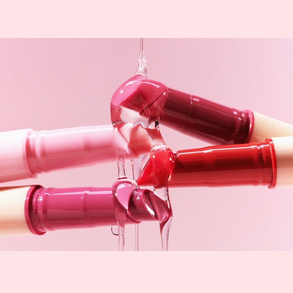 Trois tubes de gloss d'où coule du liquide. Couleurs: rose, rouge, rouge foncé et violet.