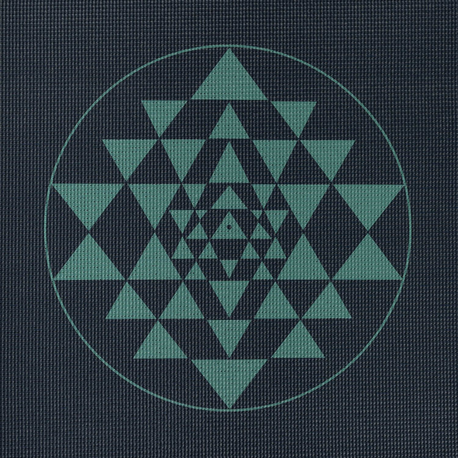 Close-up van het Yantra-patroon op een yogamat. Groen geometrisch patroon op donkerblauw.