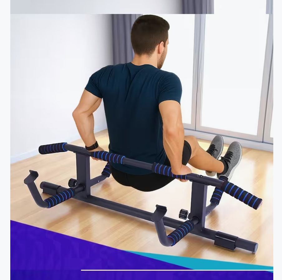 Personne assise sur une barre de traction noire avec poignées bleues. La barre est posée au sol.