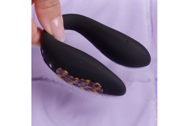 Zwart, U-vormig product. Gedeeltelijk vastgehouden door een hand. Met bruin patroon element.