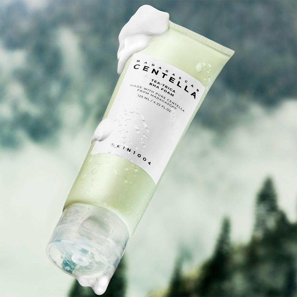 Tube vert avec mousse et gouttes d'eau, flottant sur fond flou.