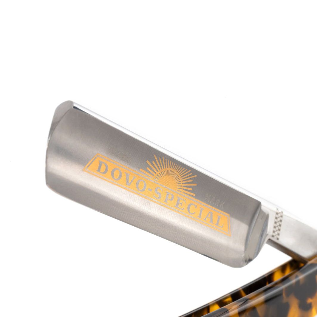 Gros plan sur la tête du rasoir. Lame avec logo et texte DOVO SPÉCIAL. Manche imitation écaille de tortue.