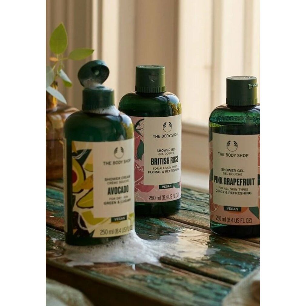 Trois flacons de gel douche. British Rose, Avocado, Pink Grapefruit. Bouchons verts, étiquettes blanches. Vegan. Mousse.