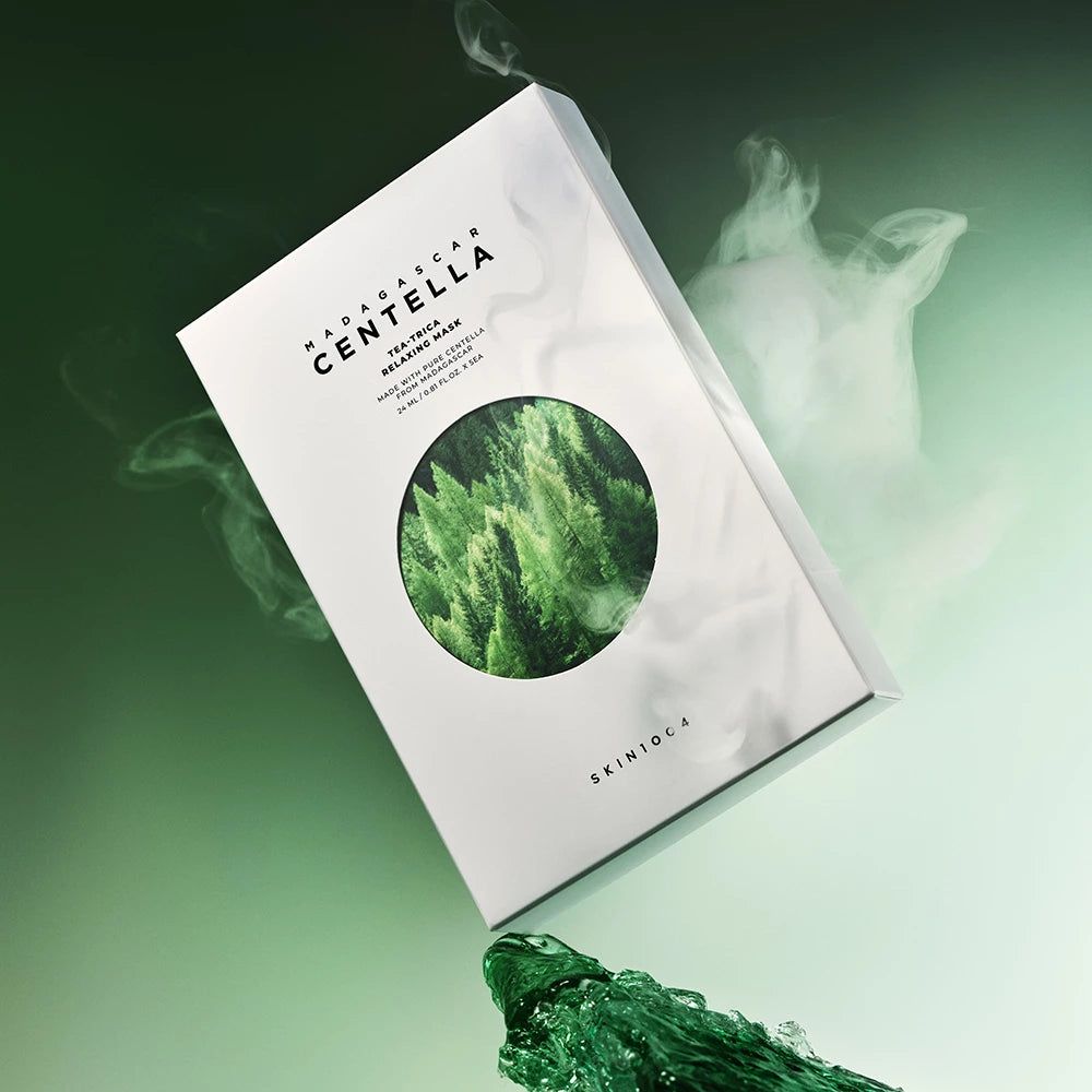 Boîte avec nom du produit et motif forestier, entourée de vapeur et de liquide vert. Texte: Madagascar Centella, Tea-Trica Relaxing Mask, SKIN1004.