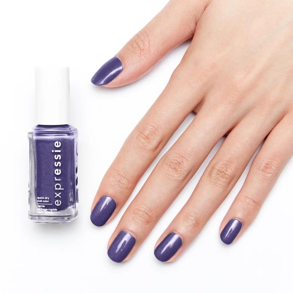 Flacon de vernis à ongles et ongles vernis violets. Inscription: Expressie. Main avec ongles vernis.