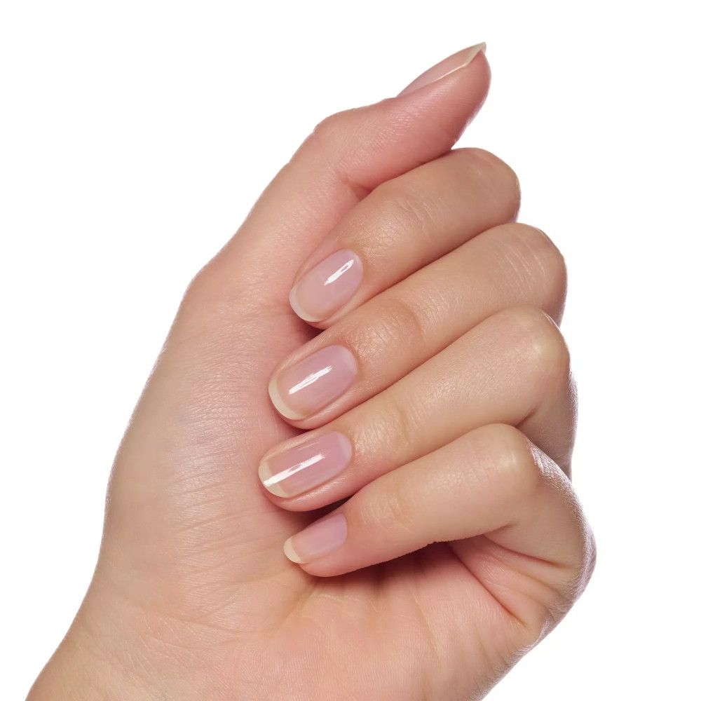 Main avec ongles vernis. Ongles ovales et brillants. Teint clair.