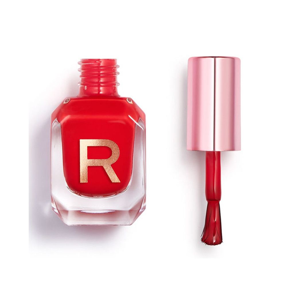 Rode nagellak in een doorzichtige fles met gouden "R" en roségouden applicator.