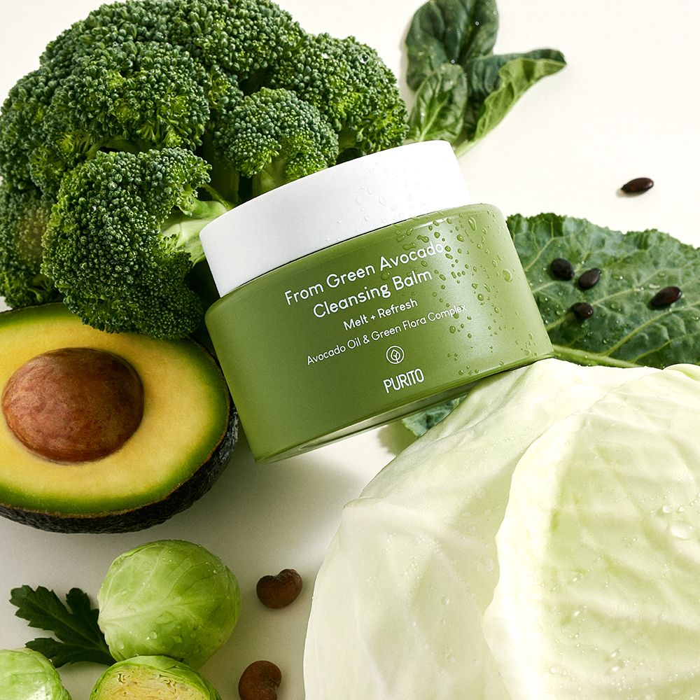 Pot vert entouré de brocoli, d'un avocat coupé et de chou.