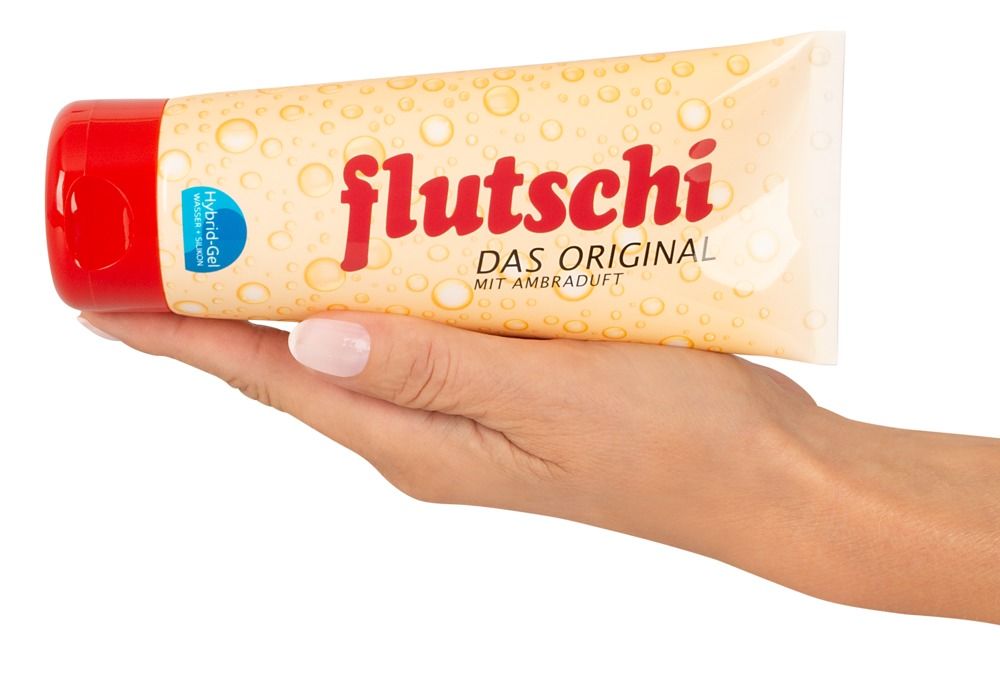 Main tenant un tube. Inscription: flutschi, DAS ORIGINAL, MIT AMBRADUFT. Bouchon rouge.
