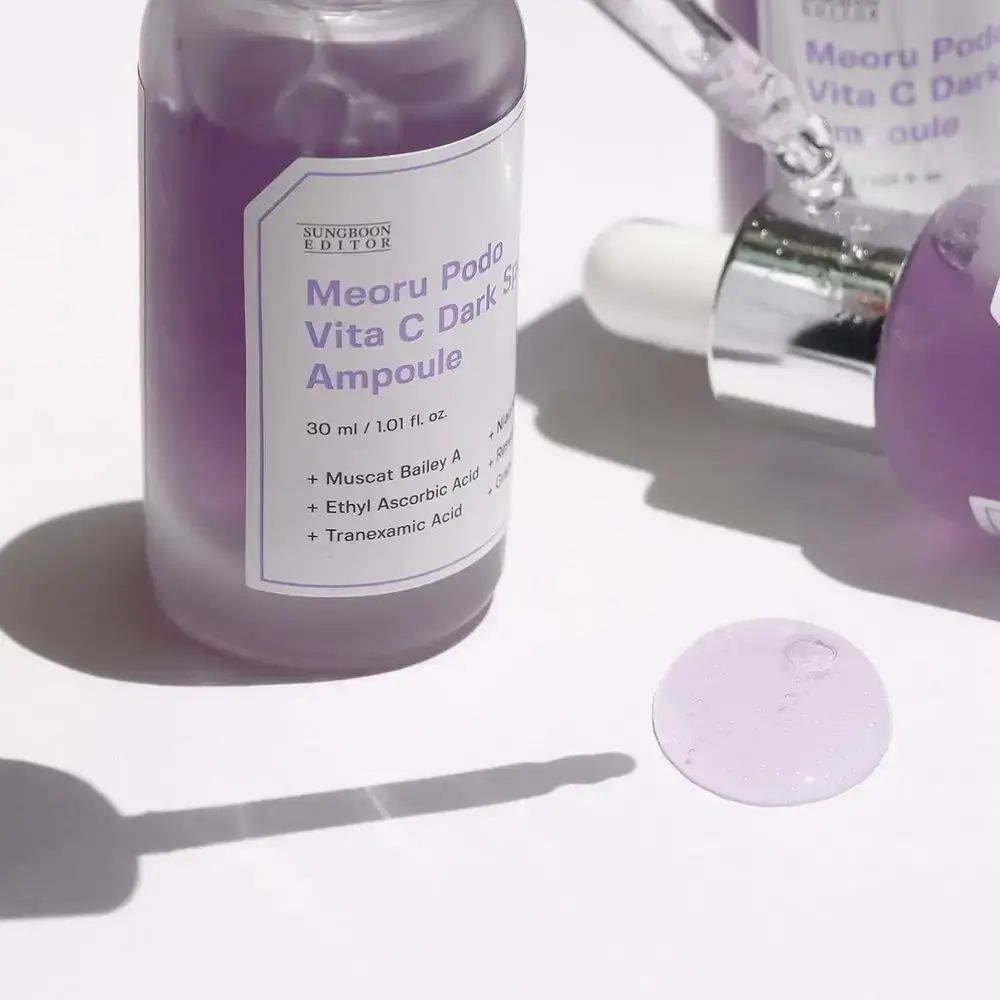 Twee paarse flessen met witte etiketten. Productnamen en ingrediënten gedrukt. Pipetten.