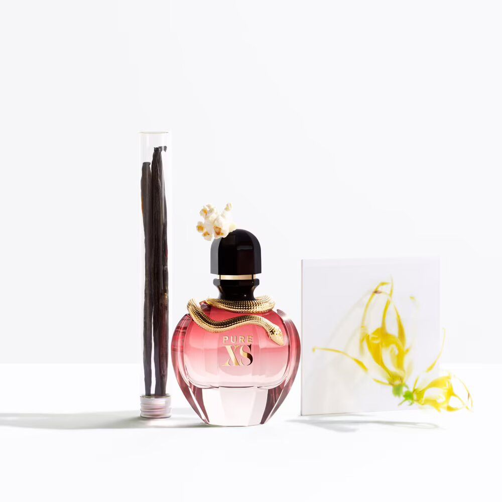 Flacon de parfum, gousses de vanille et fleur. Flacon rond, rose transparent, serpent doré. Gousses de vanille en tube.