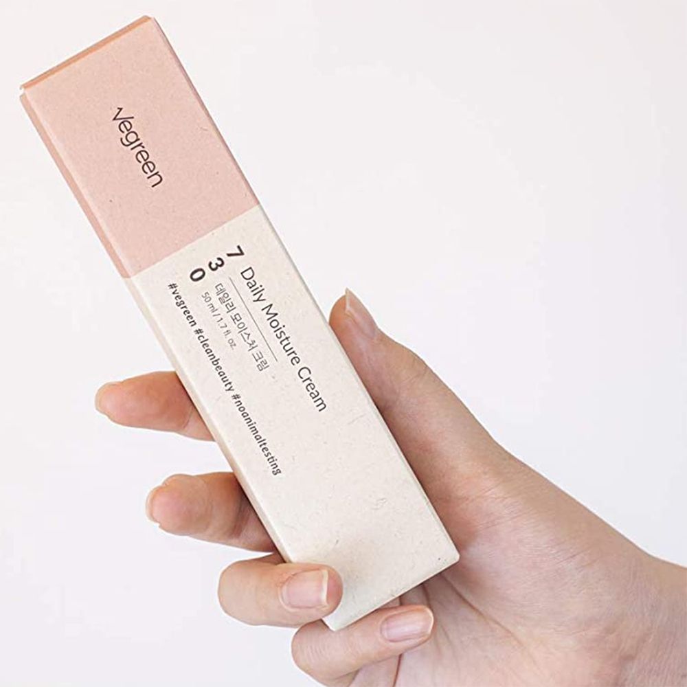 Emballage du produit dans la main. Inscription Vegreen et nom du produit. Contient 730 Daily Moisture Cream. Hashtags : #vegreen #cleanbeauty #noanimaltesting.